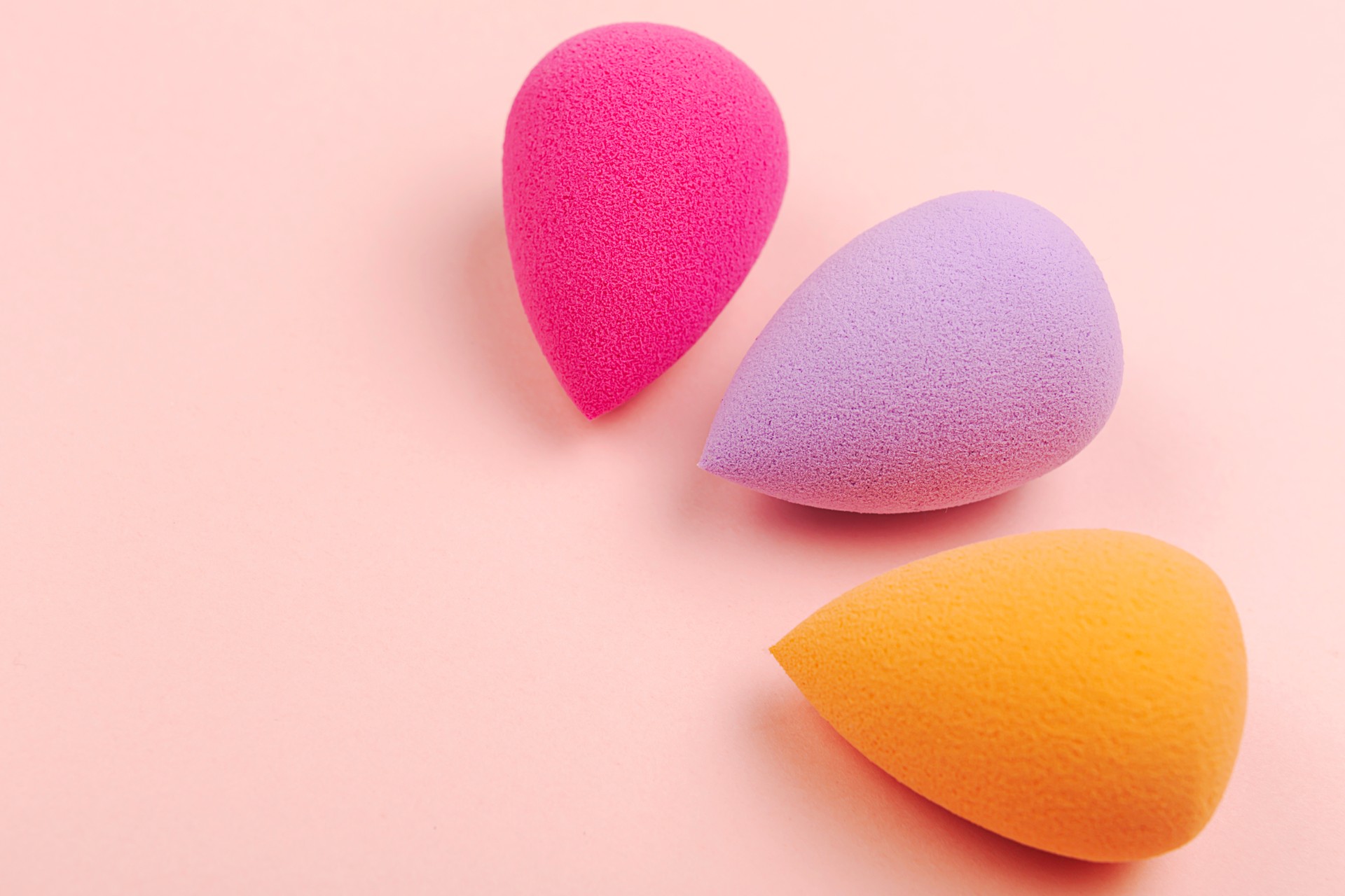 Colorful beauty sponges on pink background